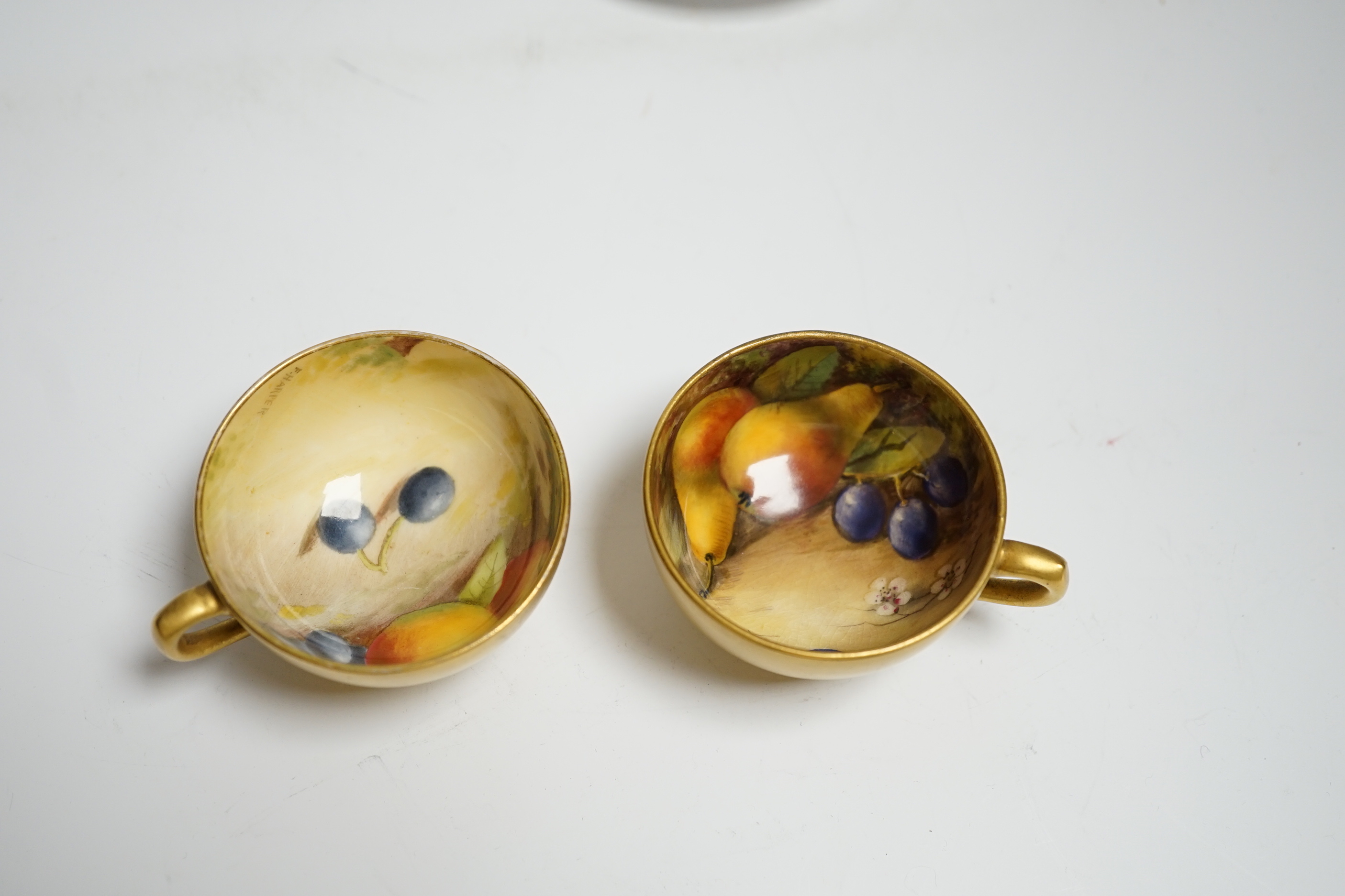 A pair of Royal Worcester fruit painted miniature cabinet cups and saucers, signed F. Harper and W.H. Austin
